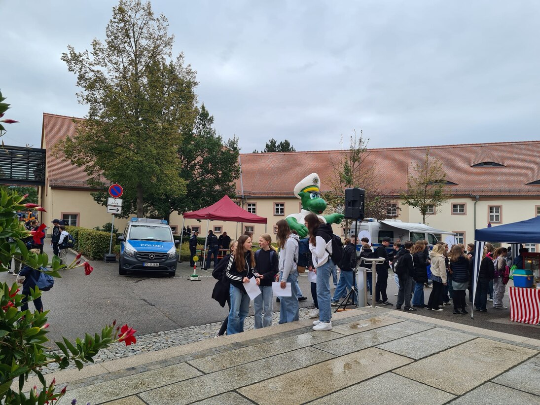 Menschen stehen im Hof der Stadtverwaltung. Der Poldi steht im Hintergrund.