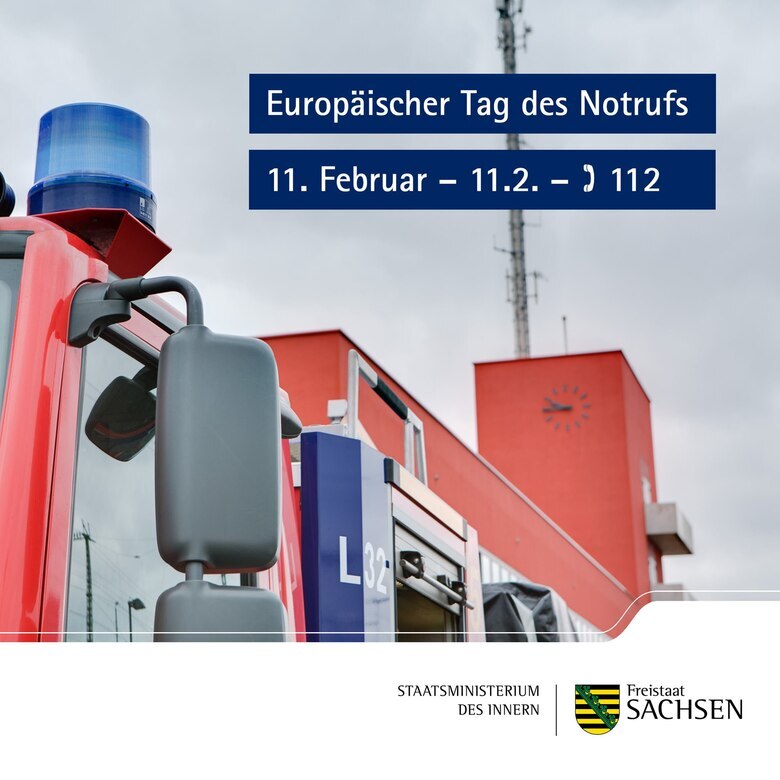 Man sieht Teile eines Feuerwehrautos mit blauem Rundumlicht und den Turm einer Feuerwache.